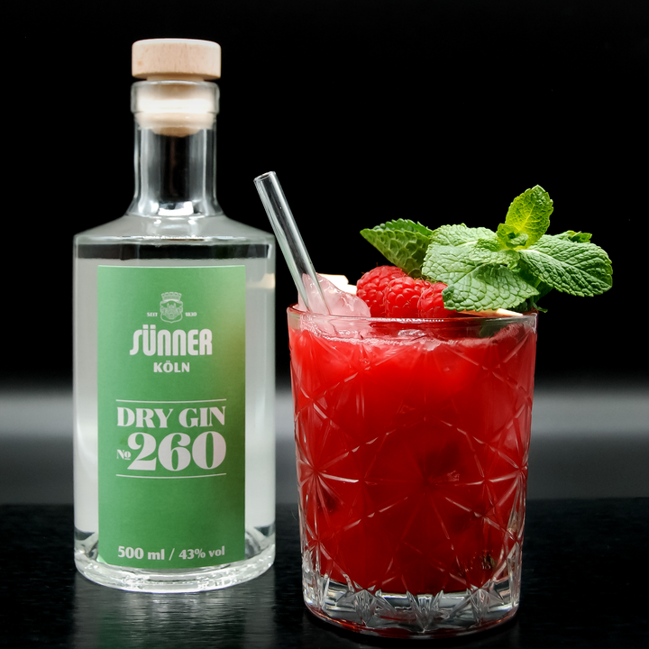 Der Sünner Dry Gin No.260 mit dem roten Cocktail "Rasperry Gin Sour" rechts daneben