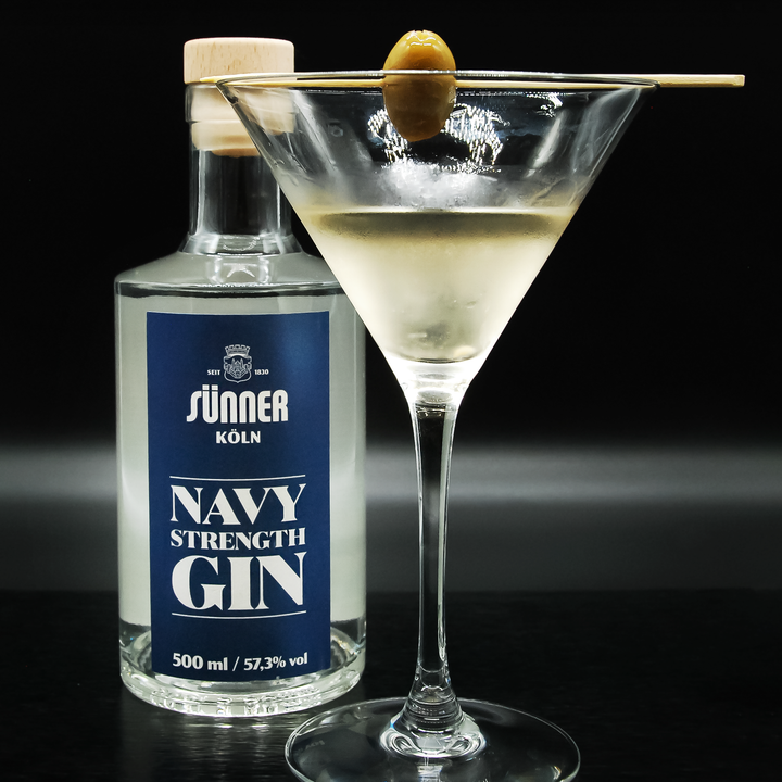 Der Sünner Navy Strenght Gin in Flaschenform und rechts daneben als Martini Cocktail